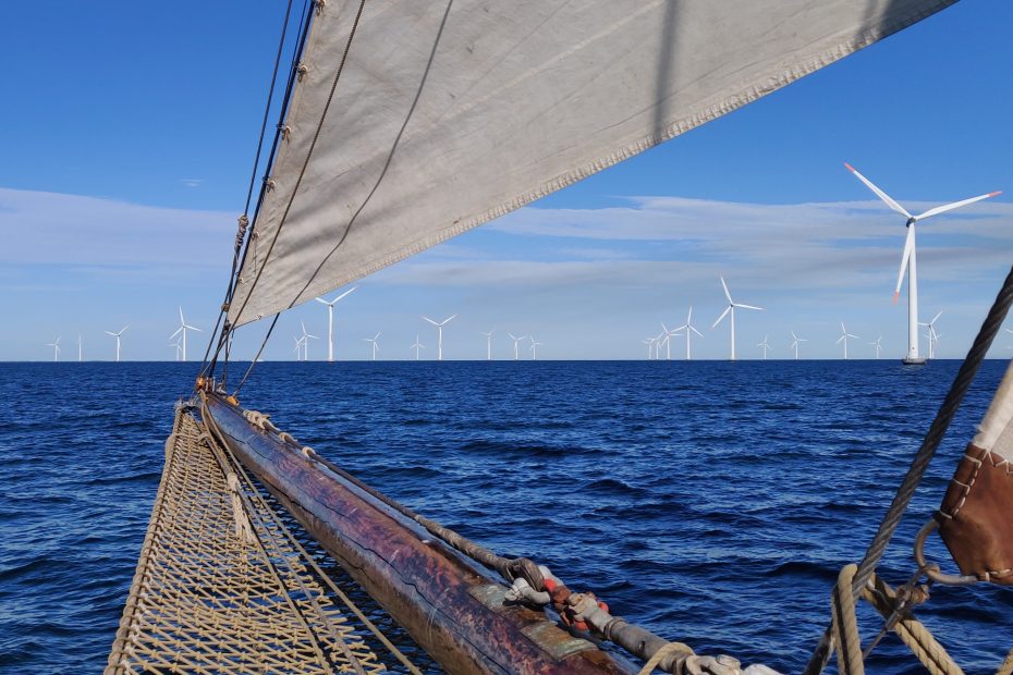 Der Wind der Ostsee in den Segeln der Nobile, bringt das Schiff voran - ebenso die Rotoren der Windräder im Offshore Windpark voraus.