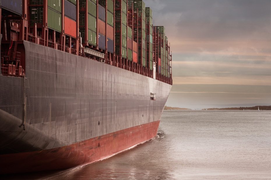 Ein voll beladenes Containerschiff fährt auf der Elbe. Das Bild steht symbolisch für globale Lieferketten.