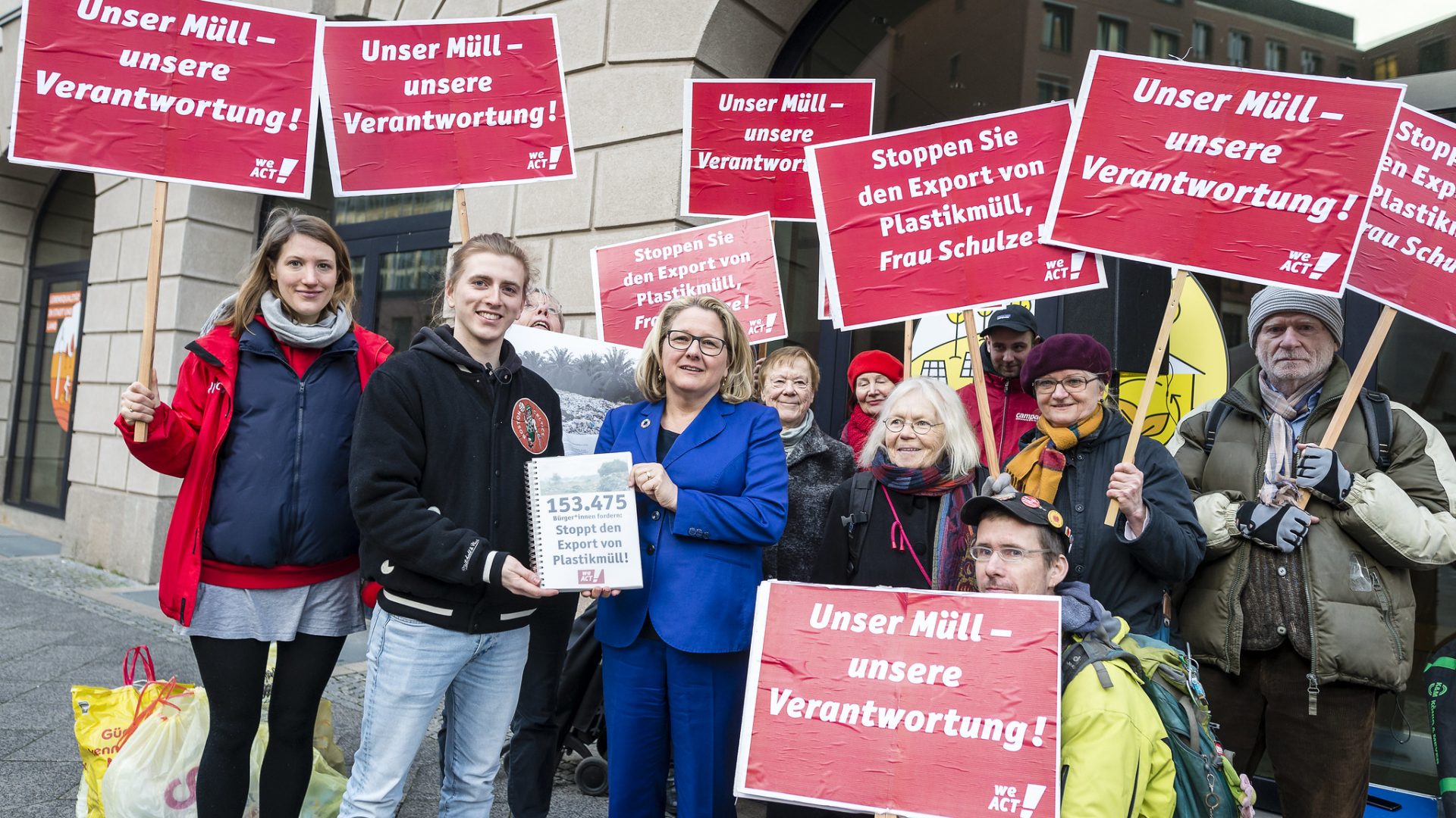 Eine Gruppe Menschen überreichen abgeschlossene Petitionen an Umweltministerin Svenja Schulze.